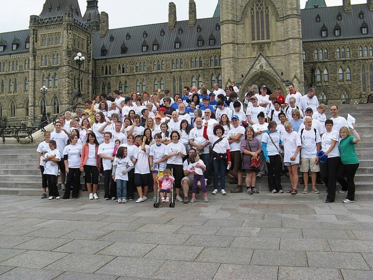 Walk2Hear participants gathered on the steps of Parliament Hill in Ottawa, wearing white Walk2Hear shirts