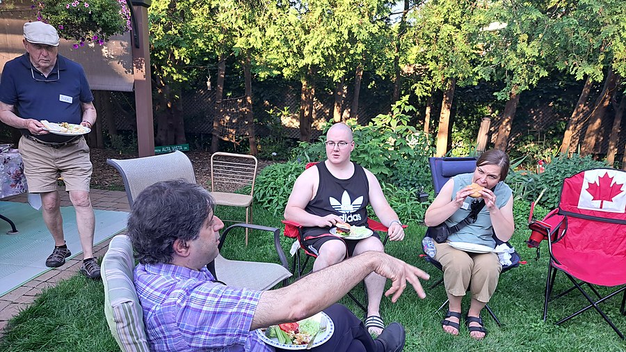 Members share a backyard meal at the branch summer barbecue hosted by our President